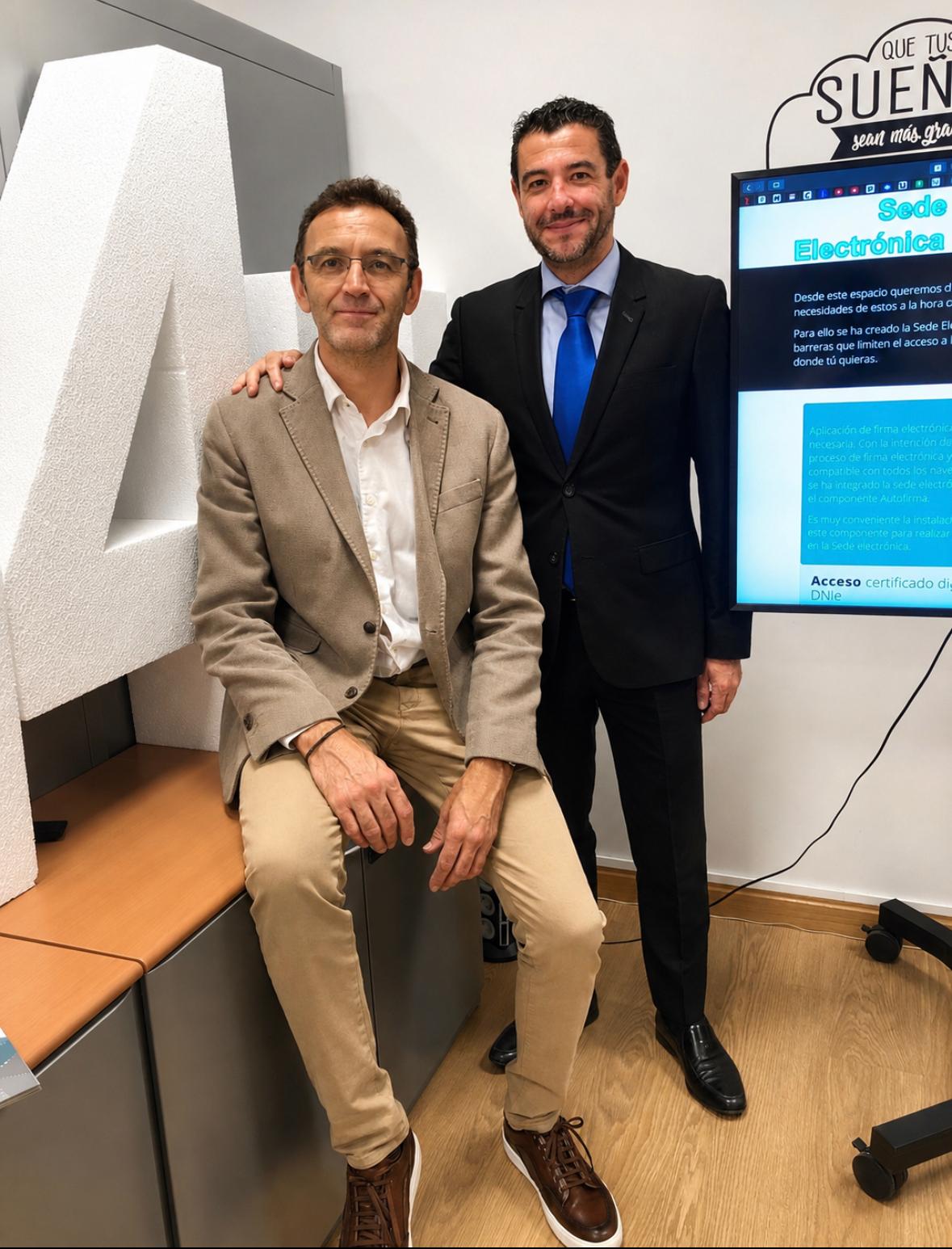 Ángel de Antonio Bermejo (izquierda) y Miguel Ángel Domínguez (derecha), socios cofundadores de Add4u, junto a la letra A de la marca y una pantalla con la Sede Electrónica